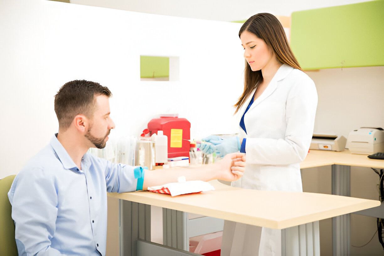 A phlebotomist preparing a seated patient's arm for a blood draw in a clinic drawing room